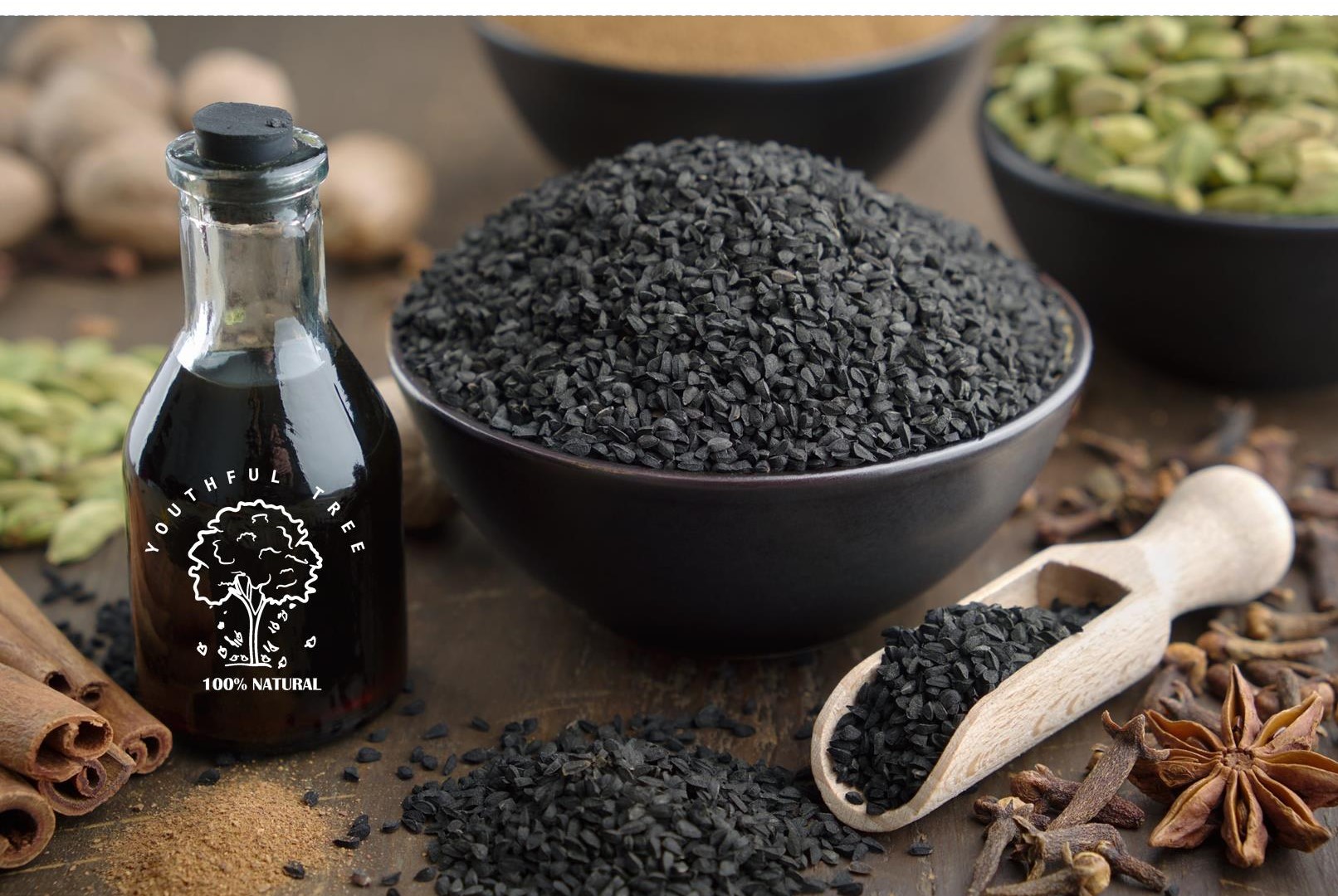 a bowl of black seeds and a bottle of oil